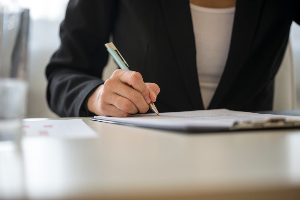 Low angle view of a woman signing contract